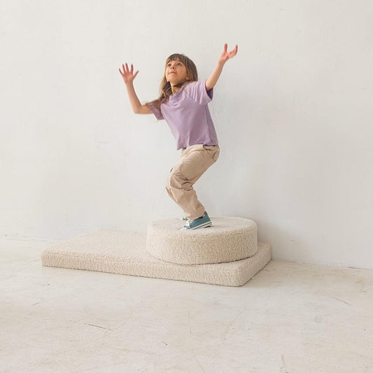 girl playing on boucle mattress and boucle pouf by bettys home, teddy boucle mattress for modern nursery