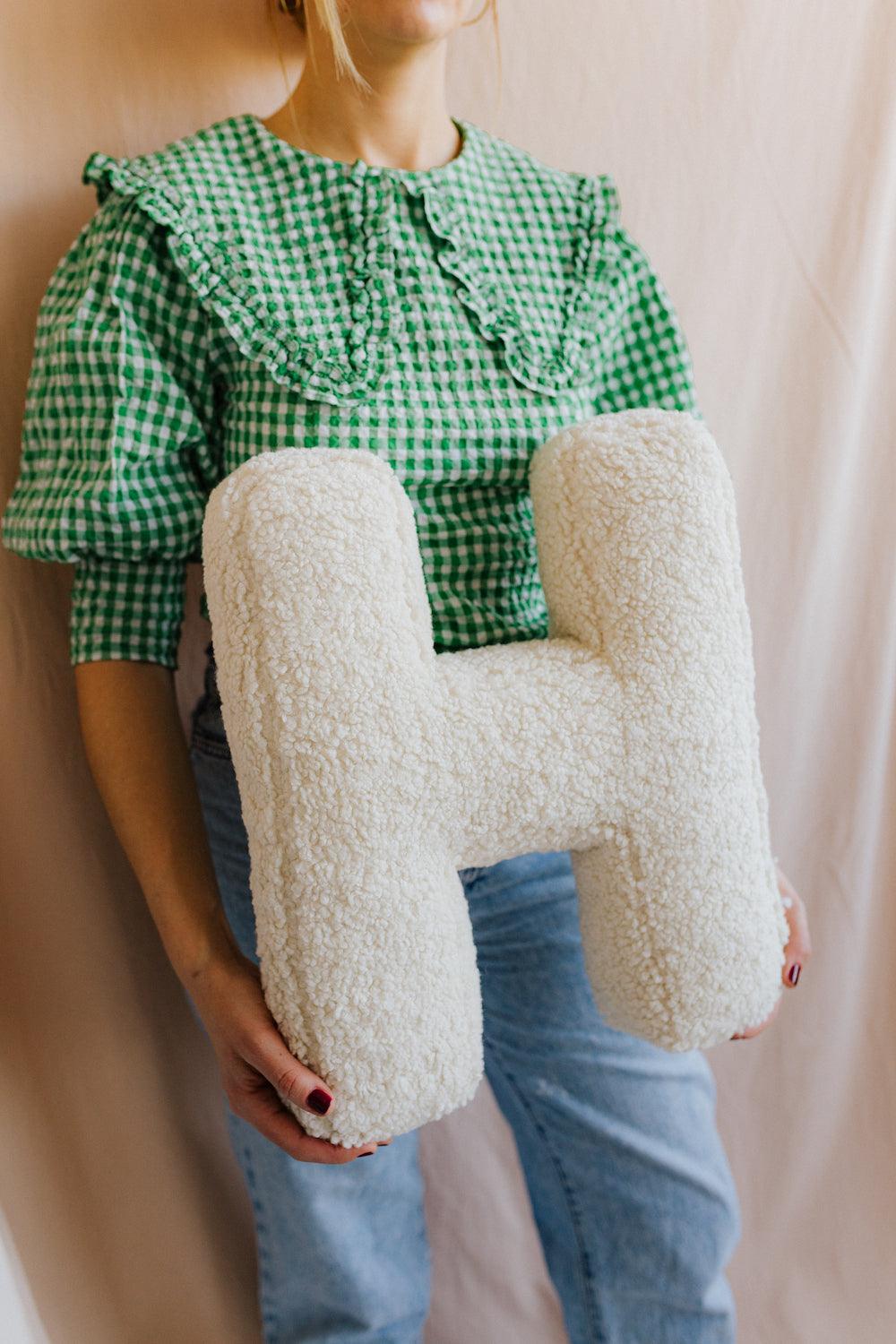 boucle letter cushion H teddy pillow by bettys home held by woman in green shirt gift idea for mom