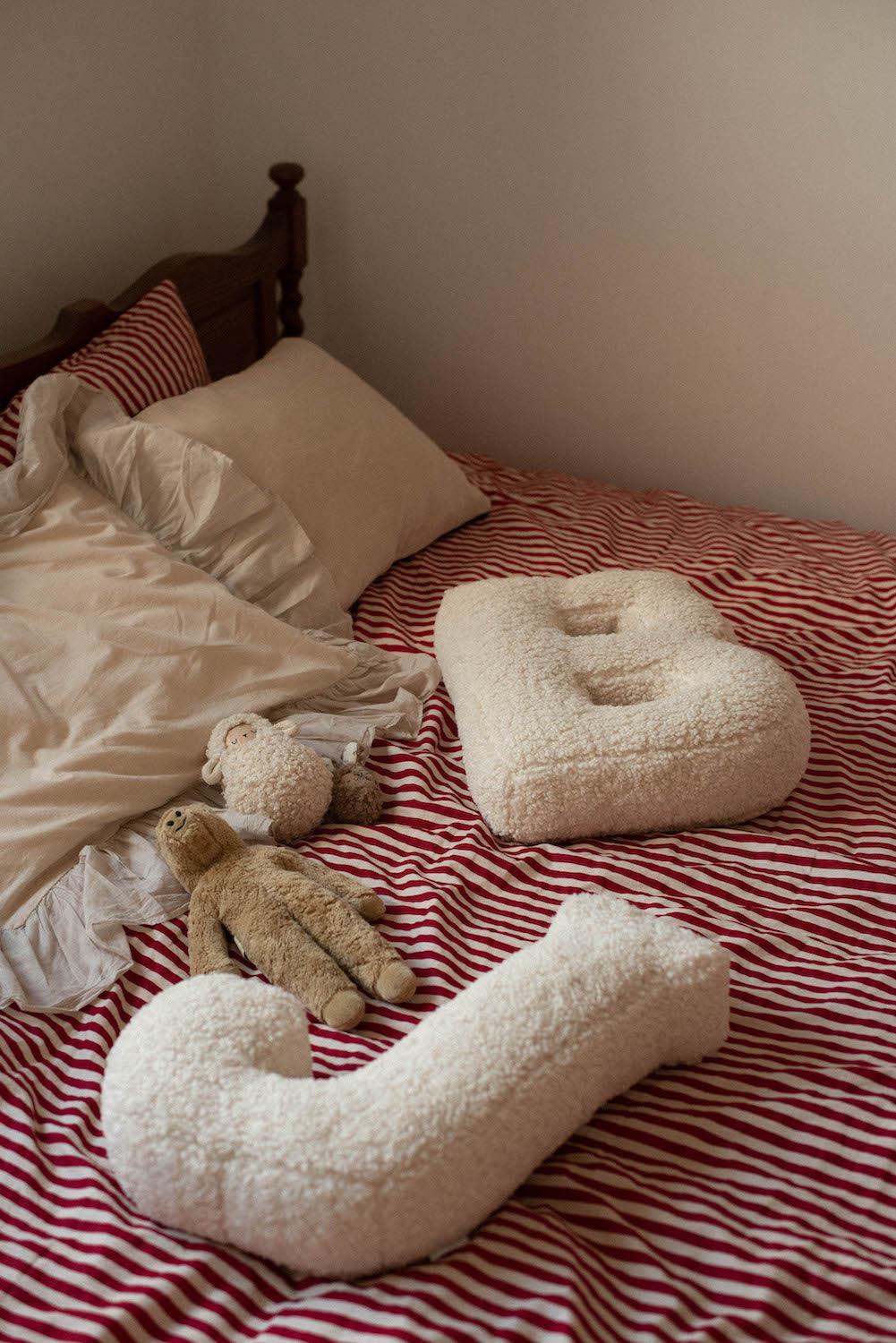 boucle letter cushion B and J teddy pillow by bettys home lying on bed as bedroom decoration idea