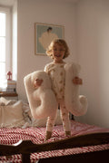 little boy standing on bed with boucle letter cushion B and J teddy pillow by bettys home in his hands
