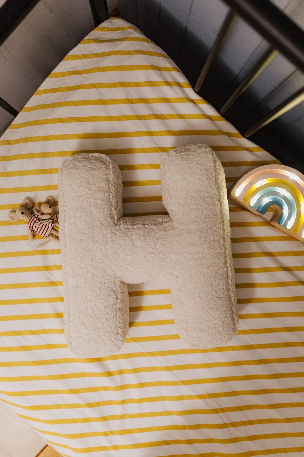 boucle letter cushion H teddy pillow by bettys home next to mailed mouse in kids crib