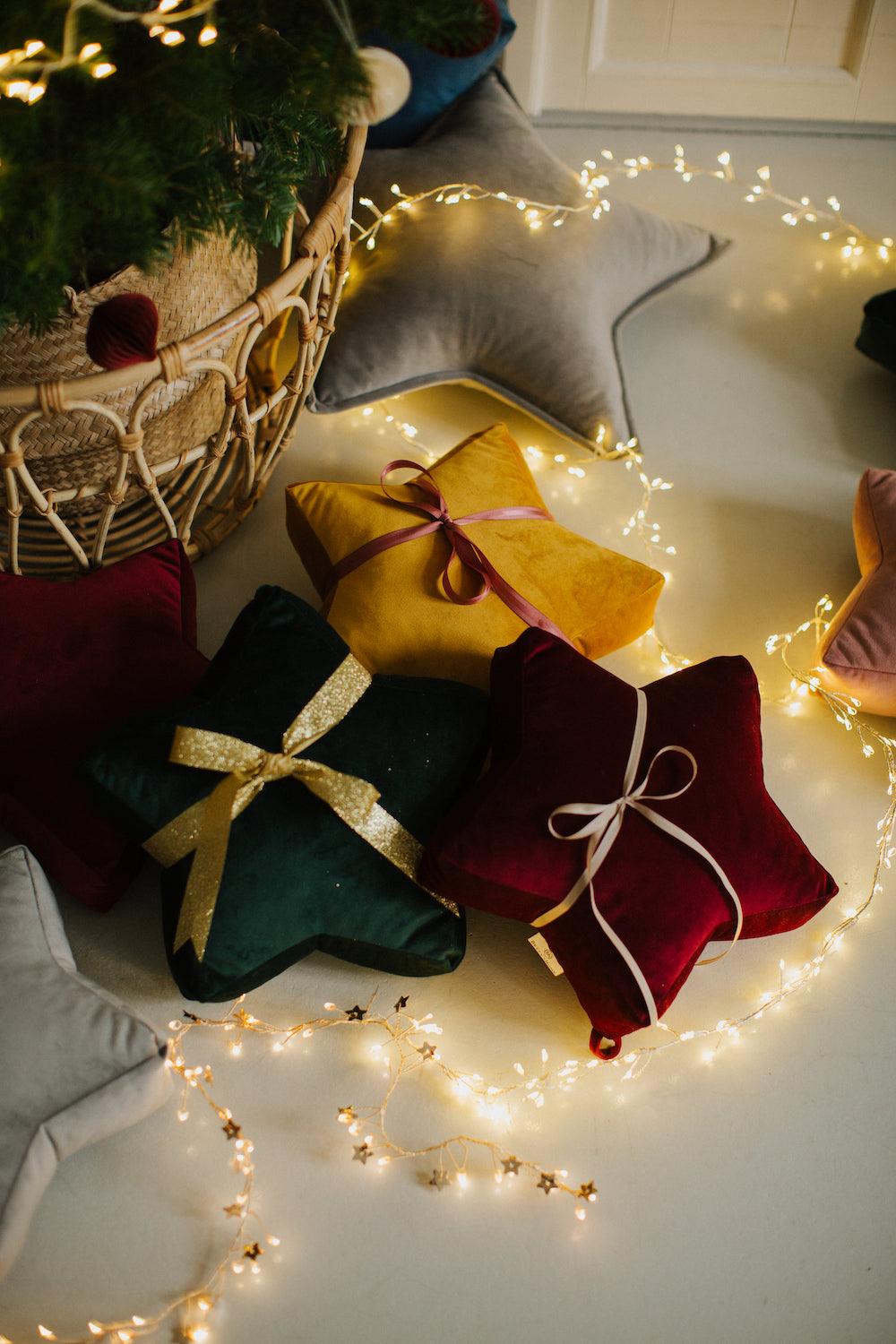 velvet small star cushion wine red by bettys home wrapped in a gold ribbon under the Christmas tree 
